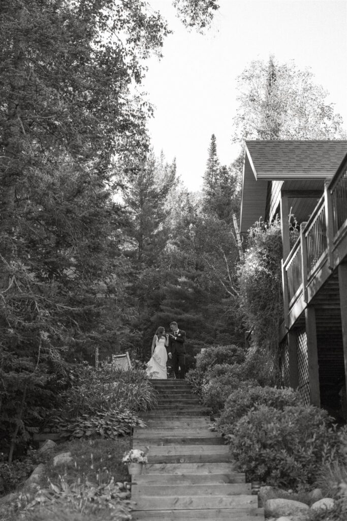 Bride and groom stand at the top of their cabin steps in Walker, Minnesota