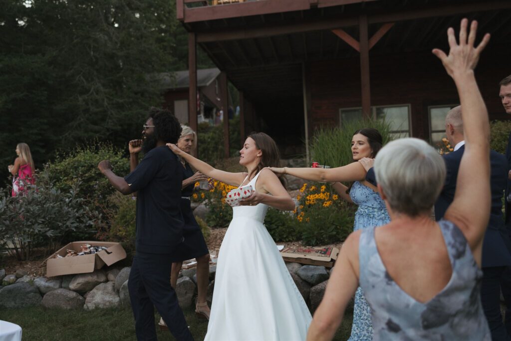 Bride and DJ lead a conga line in Walker, Minnesota wedding