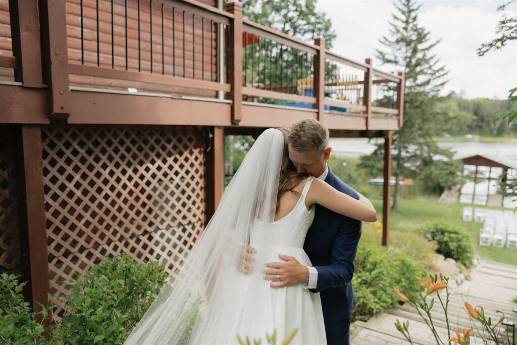 Minnesota groom hugs his bride to be outside their cabin in Walker, Minnesota