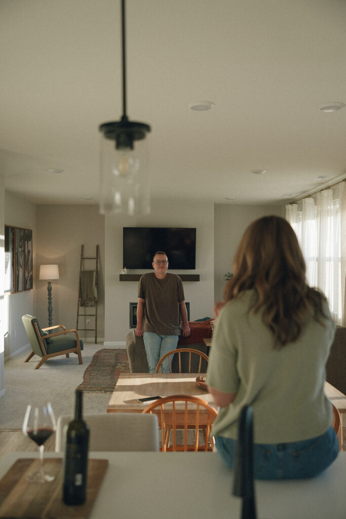 Couple gazes at each other from opposite sides of the living room