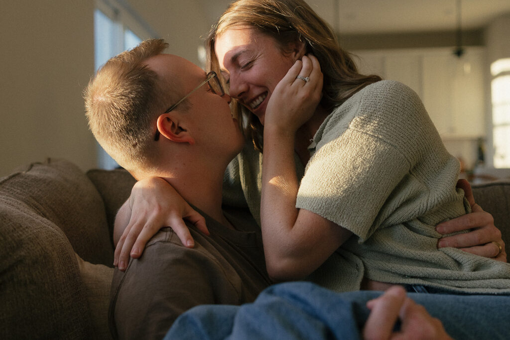 Woman brushes her hair back as she leans in to kiss her husband