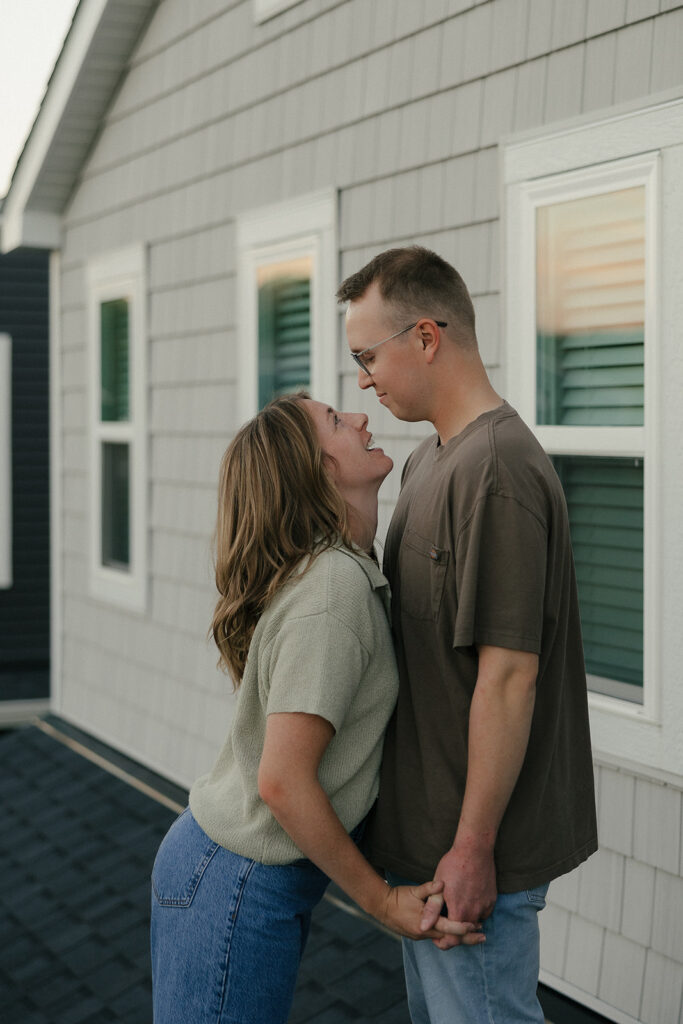 Woman leans in to tell her husband something as they stand on roof