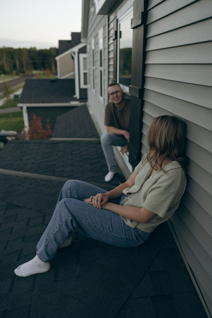 Man sits in window while looking at his wife