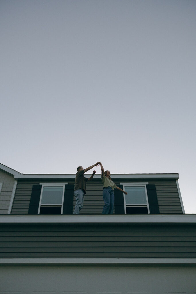 Married couple dances on the roof of their home during Minnesota couples photography session