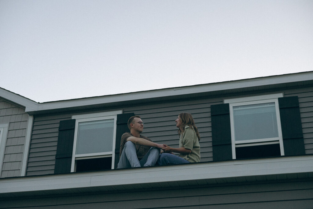 Married couple sits in quiet conversation on the roof of their Minnesota home