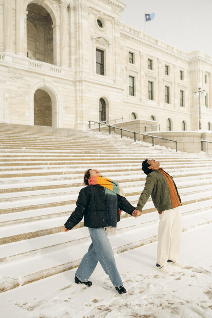 Cinematic engagement photos where couple catches snowflakes with their tongues