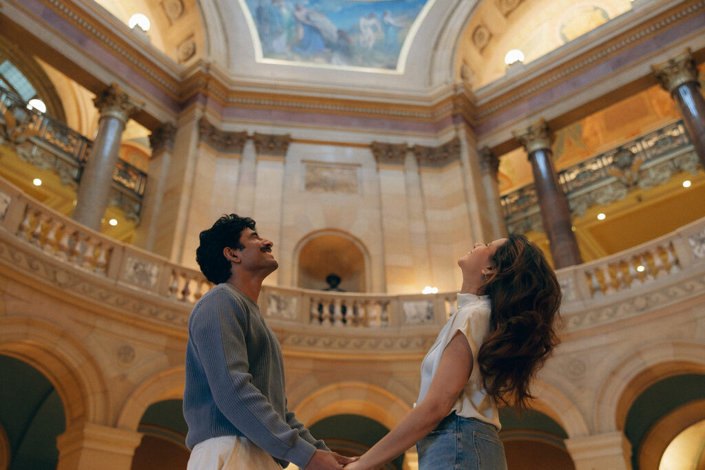Couple tilting their heads back towards Minnesota Capitol Building ceiling