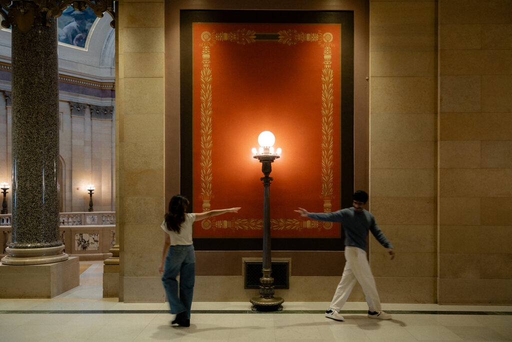 Couple reaching for each other across marble hallway