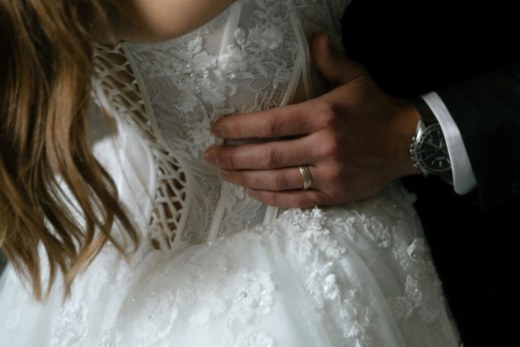 Groom's hand wraps softly around bodice of bride's gown at Minneapolis microwedding
