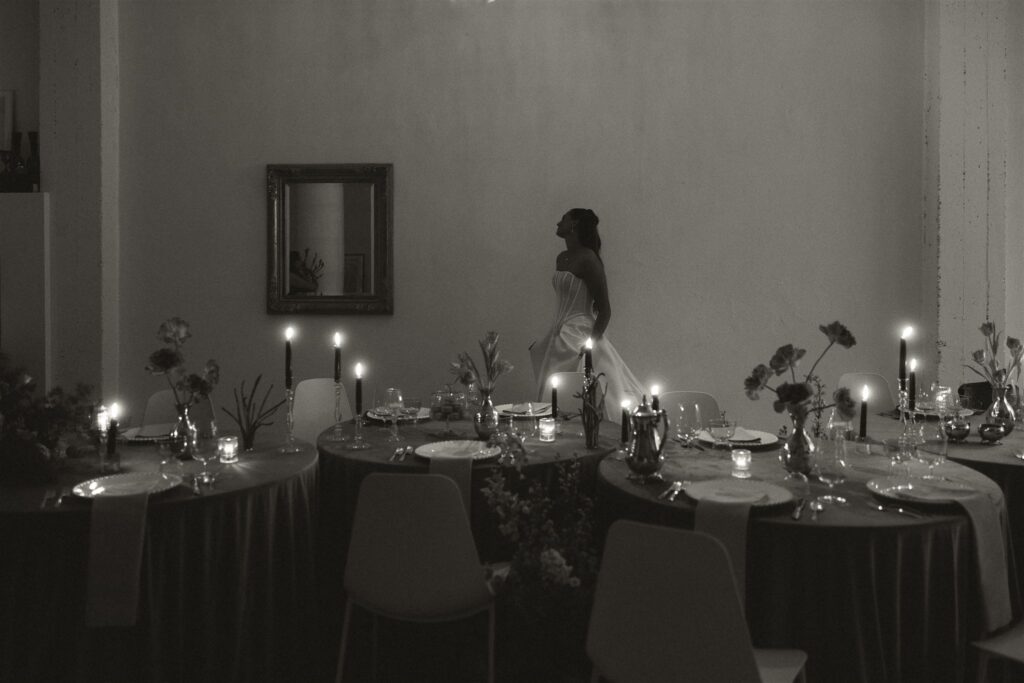 Bride wanders around dreamy, candlelit microwedding reception space