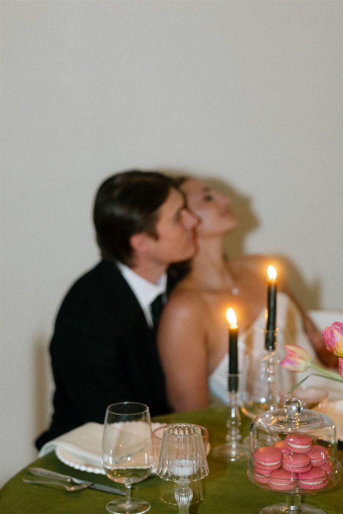 Bride leans back into groom's lap during microwedding reception