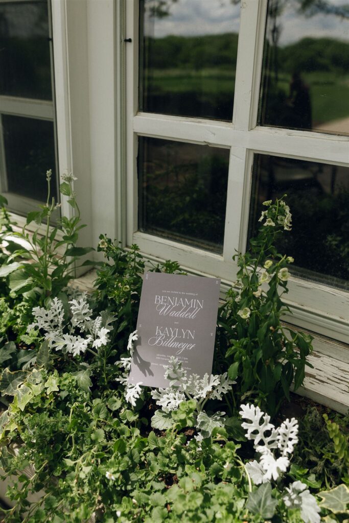 Wedding invitation styled in the flowerbeds outside window