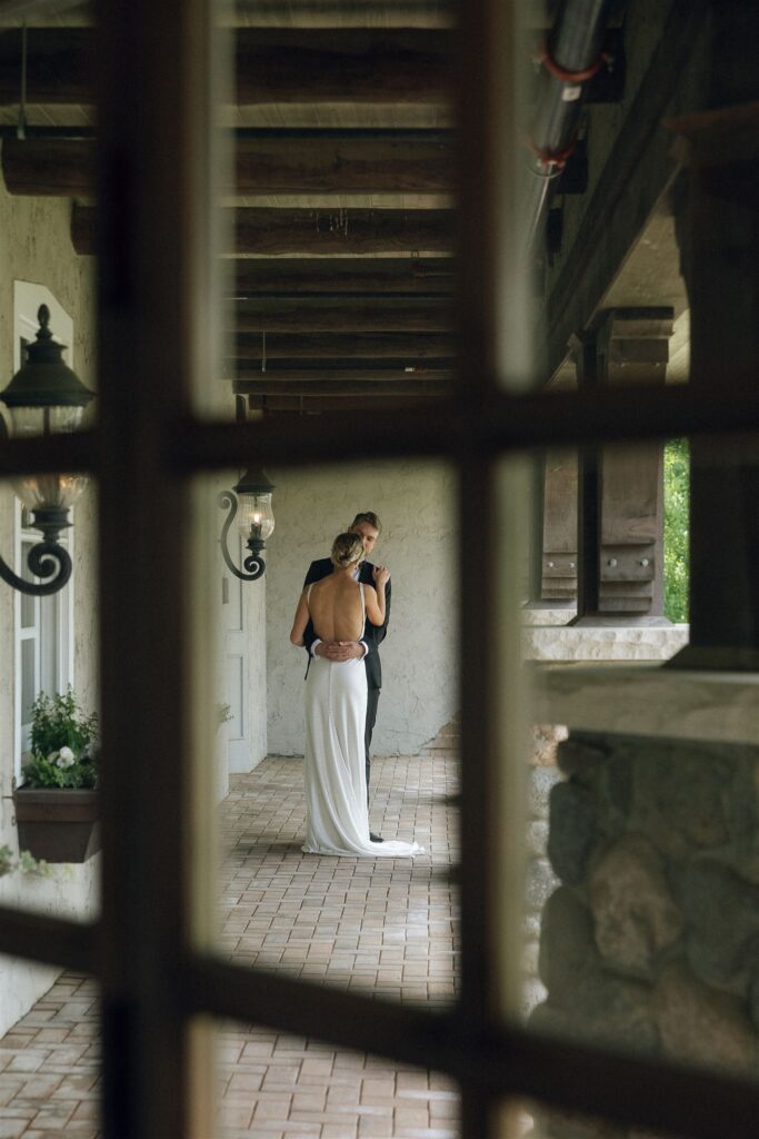 A quiet, intimate portrait of the bride captured through the windowpanes