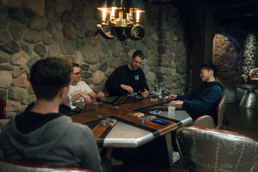 Groomsmen playing poker in the stone-walled groom’s suite