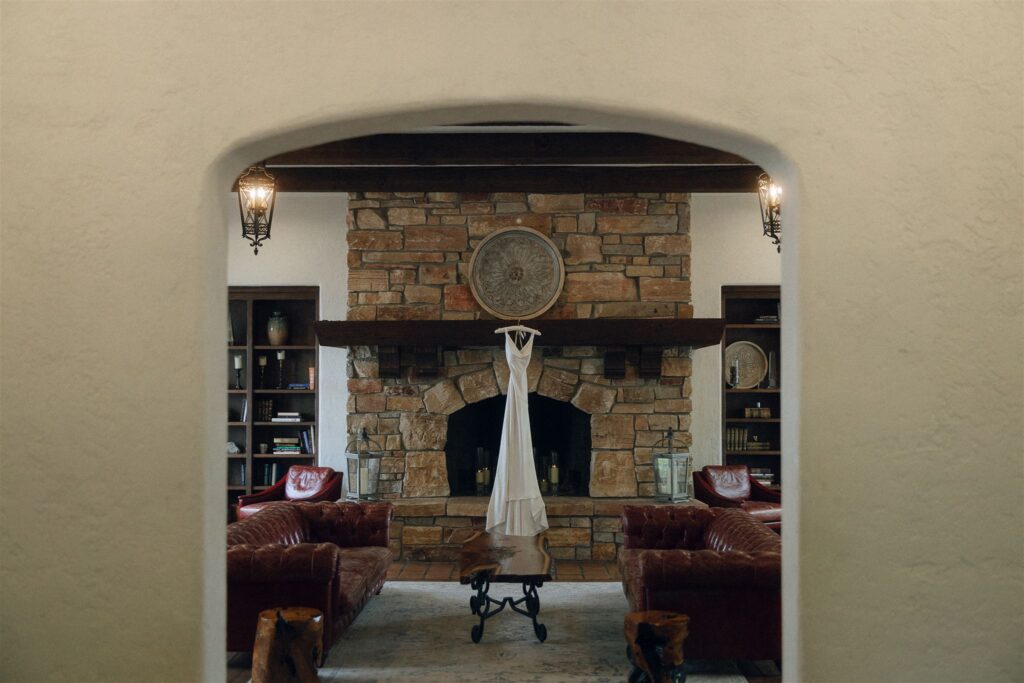 Wedding dress hanging in front of the fireplace inside Edward Anne Estate’s great room.