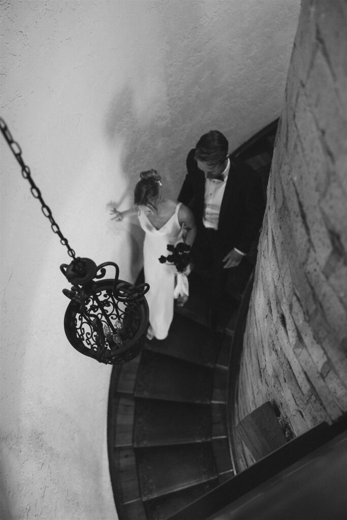 Bride and groom descending the spiral staircase inside Edward Anne Estate’s historic main house