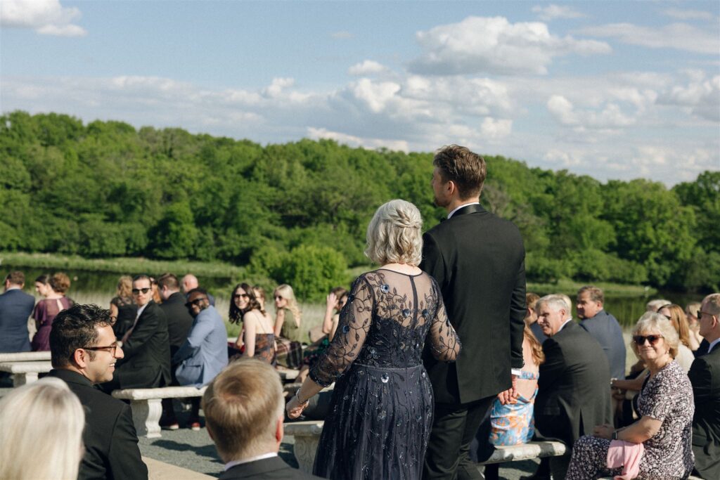 Guests gathering for an outdoor ceremony under a blue Minnesota sky at Edward Anne Estate.