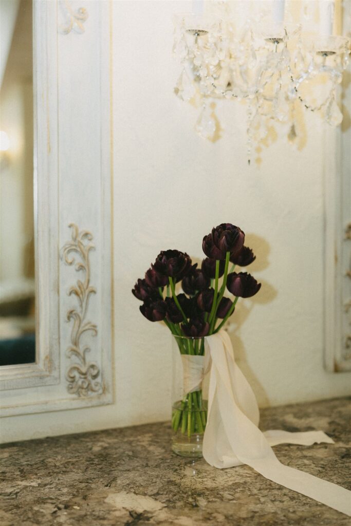 Bride’s bouquet of deep purple tulips styled in antique vanity scene.