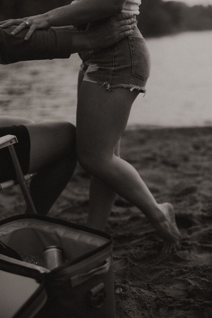 Close-up of woman’s legs stepping away from a beach cooler.