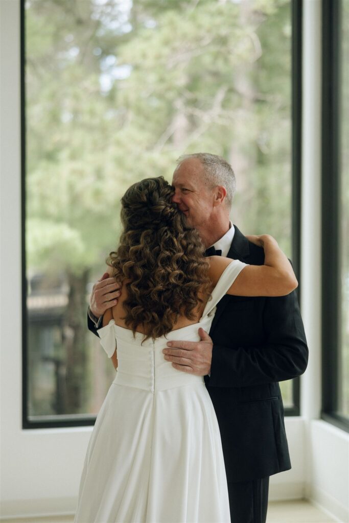 Father embracing the bride, captured in documentary style wedding photos.