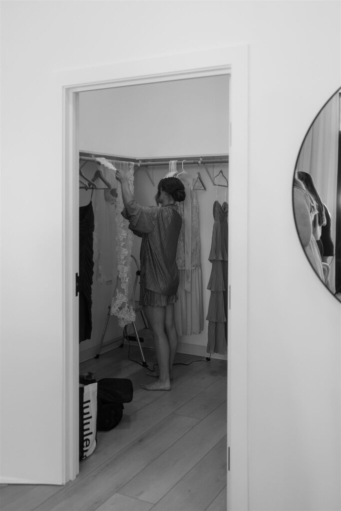 Bridesmaid steaming dresses inside the prep room in documentary style wedding photos.