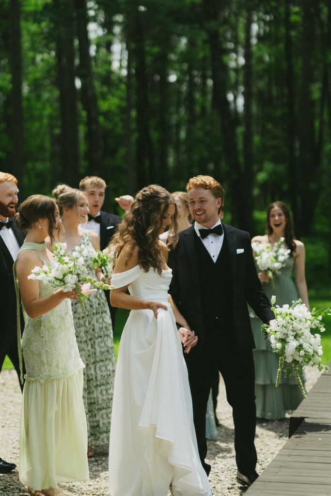 Wedding party standing under pines at Catalyst at Nature Link in Nisswa, MN.