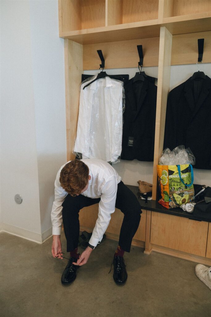 Groomsman tying his shoes before the ceremony.