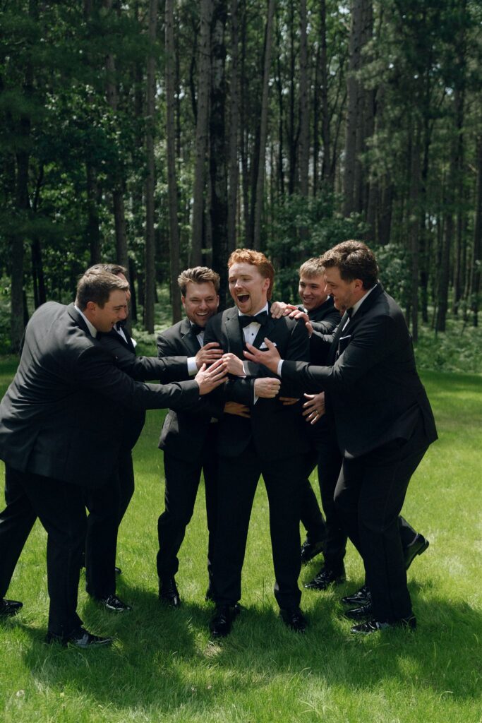 Groomsmen joking and laughing during portraits.