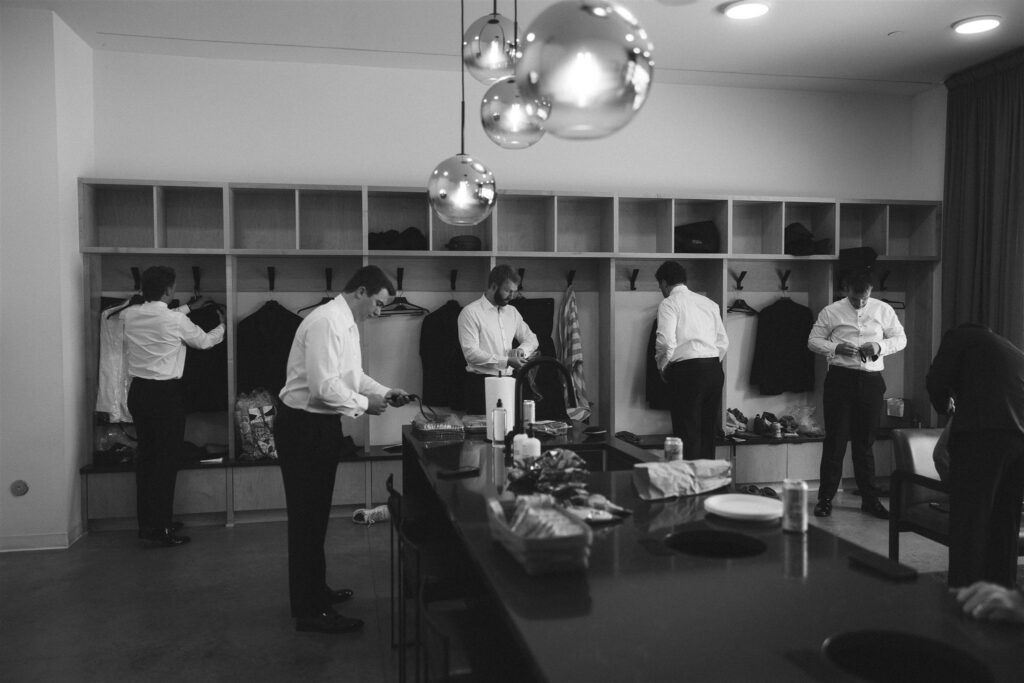 Groomsmen preparing together in the groom’s suite at Catalyst at Nature Link.