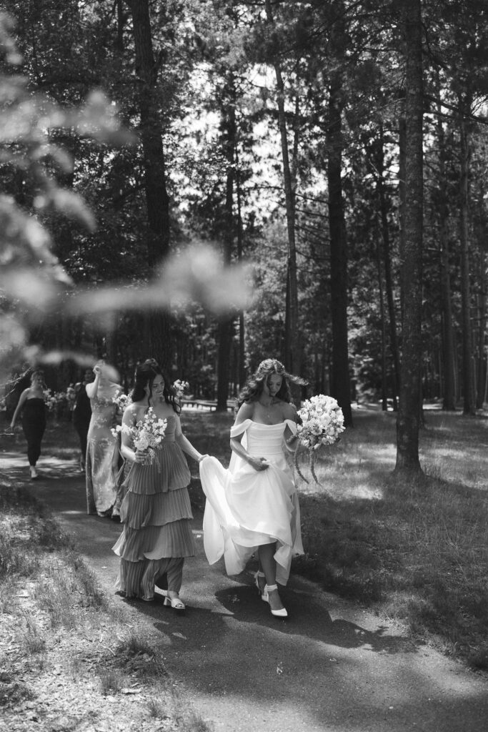 Bridesmaids walking together along the wooded path.