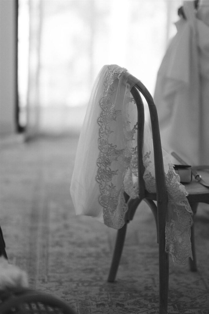 Lace veil draped over a wooden chair before the reception.