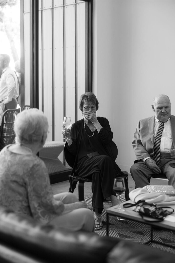 Older guests chatting in black and white documentary style photography.