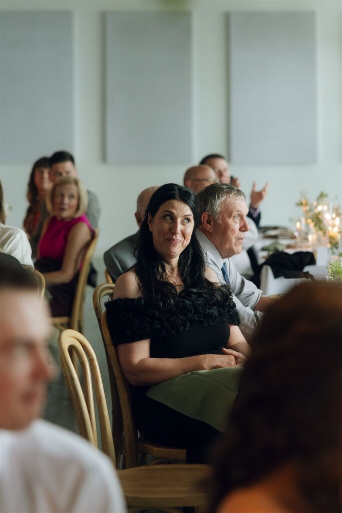 Guest laughing during toasts in documentary style wedding photos.