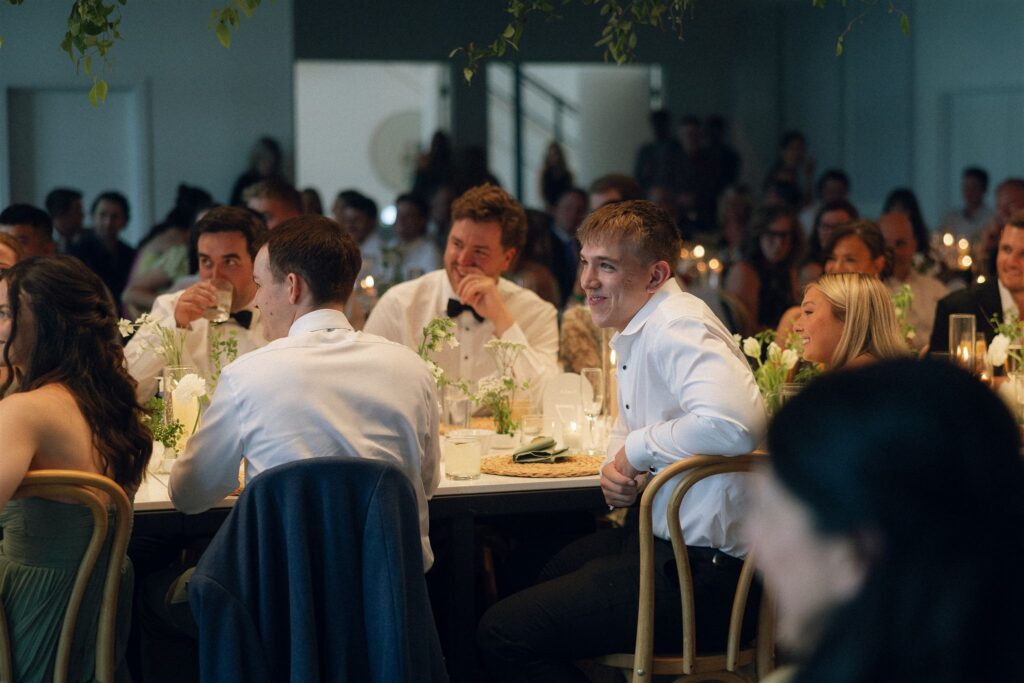 Guests seated for dinner, with candles glowing on tables.