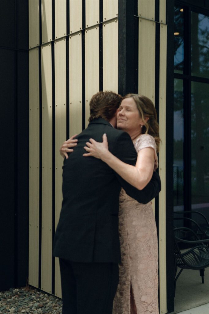 Groom hugging his mother outside the venue.