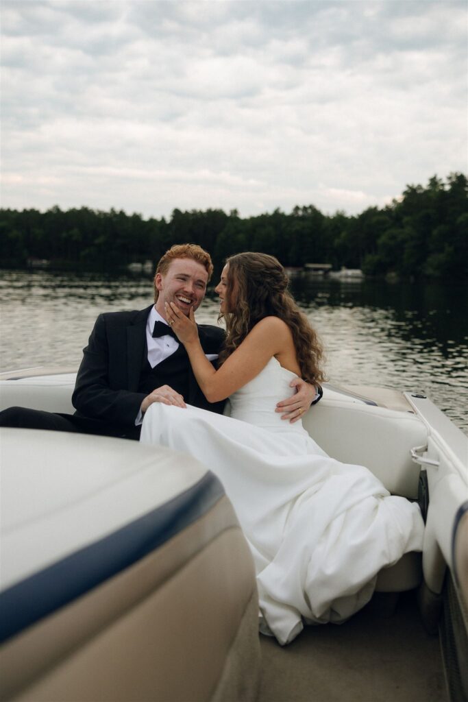Bride and groom smiling together on a speedboat at Catalyst at Nature Link during golden hour in documentary style wedding photos.