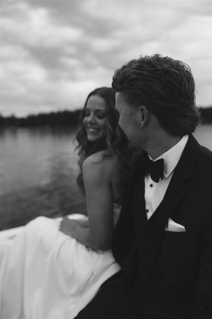 Bride and groom laughing together on the boat in documentary style wedding photos.