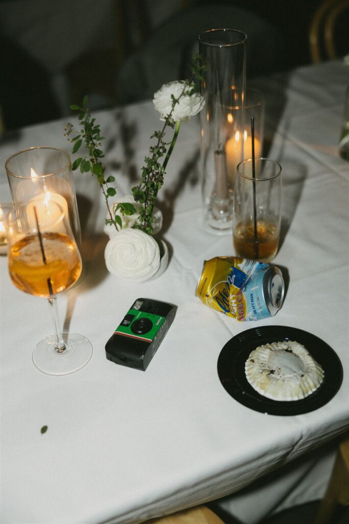 Reception table with half-finished drinks and candles, captured in documentary style wedding photos.