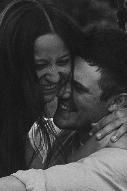 Close-up black and white portrait of Sophie and Jake mid-laugh, cheek to cheek, radiating pure joy.