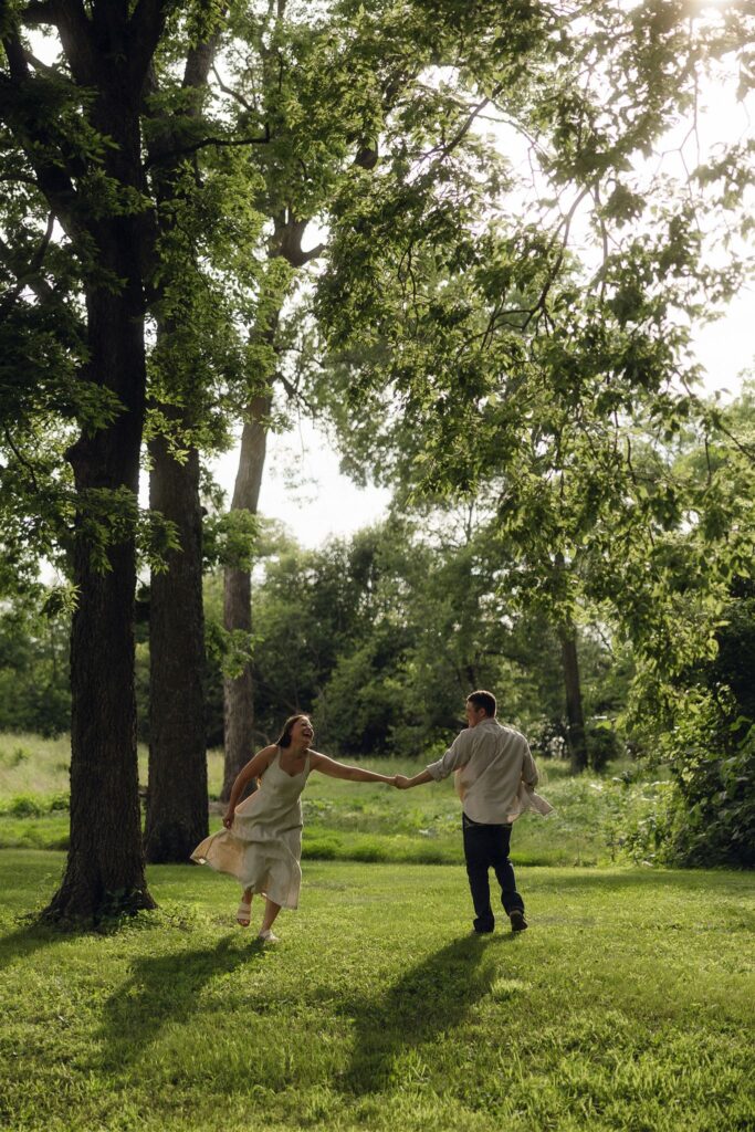 Sophie and Jake running hand in hand through tall trees, light spilling through the branches — like a frame from a film.