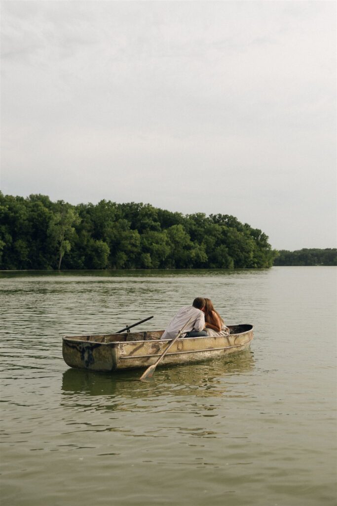 Sophie and Jake laugh together in the boat as light skims the water, a real and unposed glimpse of what cinematic engagement photography looks like when it’s just two people being themselves.