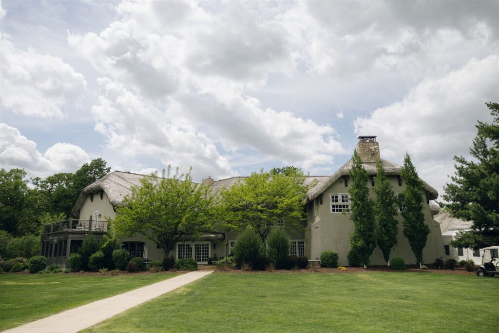 Landscape view of the Edward Anne Estate grounds with a central fountain and winding paths, showcasing the outdoor spaces available at this Minnesota wedding venue.