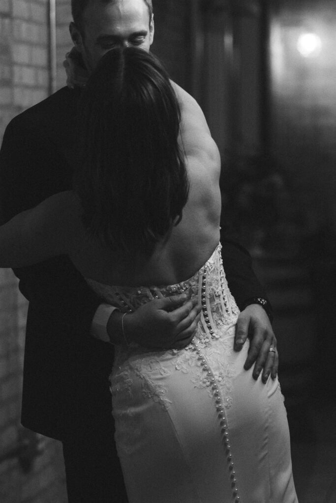 Black and white image of the couple embracing on the dance floor, capturing emotional connection and documentary-style wedding storytelling.
