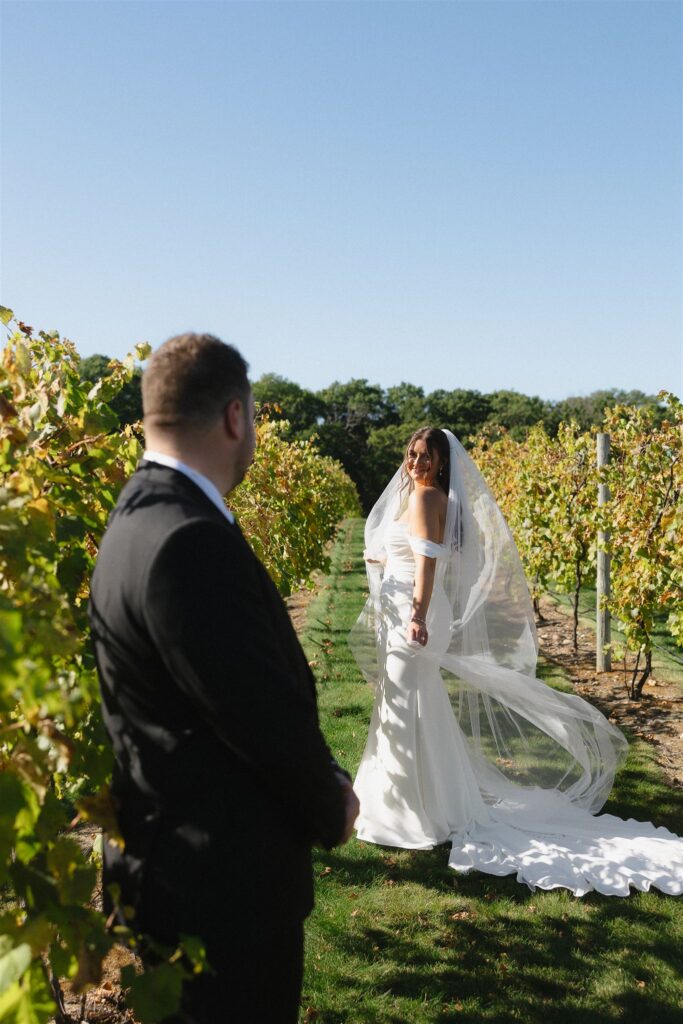 Bride twirls between the vines at 7 Vines Vineyard and Winery in Minnesota while groom looks on with adoration.