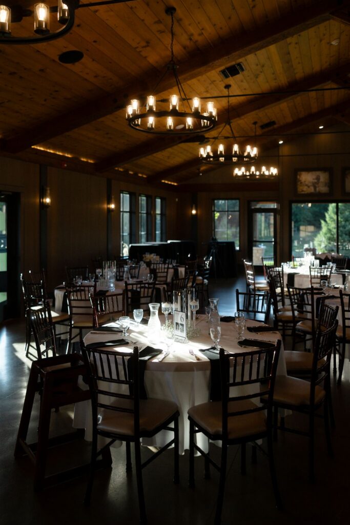 Reception space at 7 Vines set for dinner with white linens, floral centerpieces, and warm ambient lighting.